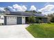 Beautiful home showcasing solar panels, a lush green lawn, and an attached two-car garage at 2797 Nordman Ave, New Smyrna Beach, FL 32168