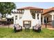 Cozy backyard fireplace with lounge seating, columns, and a view of the main house, perfect for enjoying the outdoors at 2813 Ballard Ave, Orlando, FL 32833