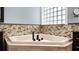 Close-up of corner bathtub, with glass block window, mosaic tile, and black fixtures at 2813 Ballard Ave, Orlando, FL 32833