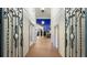 Iron gates open to reveal a covered walkway towards the home, framed by white columns and lush landscaping at 2813 Ballard Ave, Orlando, FL 32833