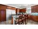Well-equipped kitchen boasts stainless steel appliances, dark wood cabinets, granite counters, and central island with bar seating at 2813 Ballard Ave, Orlando, FL 32833
