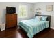 This bedroom features a light blue quilt and wood floors and furniture at 2820 Tamarind Dr, Edgewater, FL 32141
