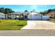 Charming single-story home featuring a well-manicured lawn, solar panels, and an attached two-car garage at 2820 Tamarind Dr, Edgewater, FL 32141