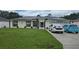 Attractive single-story home with a green lawn, solar panels, and space to park two cars at 2820 Tamarind Dr, Edgewater, FL 32141