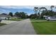 A quiet residential street is lined with well-maintained lawns and mature trees under a partly cloudy sky at 2820 Tamarind Dr, Edgewater, FL 32141