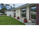 Beautifully landscaped side yard with decorative flowerpots and modern window trim at 2820 Tamarind Dr, Edgewater, FL 32141