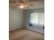 Neutral bedroom features a ceiling fan and a window with sheer curtains at 3048 Unity Tree Dr, Edgewater, FL 32141