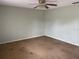 A neutral bedroom features a ceiling fan and dated carpet at 3048 Unity Tree Dr, Edgewater, FL 32141