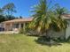Cozy single-story home featuring lush palm trees and a well-maintained lawn at 3048 Unity Tree Dr, Edgewater, FL 32141