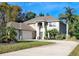 Spacious home with a three-car garage, a grand entrance with columns, and mature landscaping for added curb appeal at 305 Country Circle E Dr, Port Orange, FL 32128