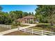 Beautiful two-story home with a long driveway, manicured lawn, and white fencing at 305 Country Circle E Dr, Port Orange, FL 32128