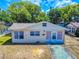 Charming single-story home with light colored siding, a quaint front yard and blue sky at 310 Legion Pl, Port Orange, FL 32129