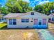 Charming single-story home with light colored siding, a quaint front yard and blue sky at 310 Legion Pl, Port Orange, FL 32129