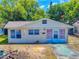 Charming single-story home with light colored siding, a quaint front yard and blue sky at 310 Legion Pl, Port Orange, FL 32129