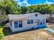 Charming single-story home with light colored siding, a quaint front yard and blue sky at 310 Legion Pl, Port Orange, FL 32129