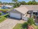 Charming home featuring an attached garage and an inviting brick-paved driveway, located near a serene pond at 42 Fore Dr, New Smyrna Beach, FL 32168