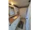 Cozy bathroom featuring a granite countertop vanity, decorative mirror, and tiled floor at 445 Bouchelle Dr # 301, New Smyrna Beach, FL 32169