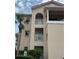 Condo exterior featuring multiple balconies, arched entryways, and well-maintained landscaping at 445 Bouchelle Dr # 301, New Smyrna Beach, FL 32169