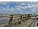 Wooden fishing pier with weathered benches overlooking serene waters at 445 Bouchelle Dr # 301, New Smyrna Beach, FL 32169