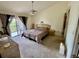 Main bedroom with a ceiling fan, balcony access, and neutral carpet at 445 Bouchelle Dr # 301, New Smyrna Beach, FL 32169