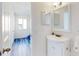 Hall bathroom with white vanity, brushed gold hardware, and decorative mirror at 4752 S Atlantic Ave # 1, Ponce Inlet, FL 32127