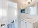 Upstairs bathroom with a white vanity with marble countertop and view of hallway with wood floors at 4752 S Atlantic Ave # 1, Ponce Inlet, FL 32127