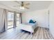 Bright bedroom features hardwood floors, great natural light and a sliding glass door with curtains at 4752 S Atlantic Ave # 1, Ponce Inlet, FL 32127