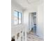 Hallway with hardwood floors, white walls, an open door and a window with natural light at 4752 S Atlantic Ave # 1, Ponce Inlet, FL 32127