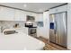 Bright kitchen featuring white cabinetry, stainless steel appliances, and a stylish backsplash at 4752 S Atlantic Ave # 1, Ponce Inlet, FL 32127