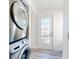 Modern laundry area features a stacked washer and dryer with an adjacent exterior door at 4752 S Atlantic Ave # 1, Ponce Inlet, FL 32127