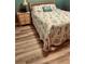 Cozy bedroom with wood-look flooring, a bedside table, and a comfortable bed at 5300 S Atlantic Ave # 3-405, New Smyrna Beach, FL 32169