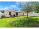 A well-manicured backyard featuring a beautiful lawn, mature tree, privacy fence, and sliding glass doors at 5304 Cordgrass Bend Ln, Port Orange, FL 32128