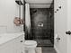 Chic bathroom showcasing a black tiled shower, modern vanity, and elegant design elements at 5304 Cordgrass Bend Ln, Port Orange, FL 32128