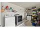 Functional laundry room with a washer, dryer, storage shelves, and utility sink at 5304 Cordgrass Bend Ln, Port Orange, FL 32128