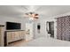 Bright main bedroom featuring ensuite bathroom, tv, and ceiling fan at 5304 Cordgrass Bend Ln, Port Orange, FL 32128