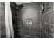 Close-up of the modern black tile shower with a built-in niche and rainfall showerhead at 5304 Cordgrass Bend Ln, Port Orange, FL 32128