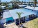 Aerial view showcases the home's screened lanai, landscaping, metal roof, and its position in the neighborhood at 650 S Pine St, New Smyrna Beach, FL 32169
