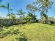 Large backyard featuring lush landscaping, green grass, and a wood fence for privacy at 650 S Pine St, New Smyrna Beach, FL 32169