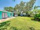 Expansive backyard showcasing mature trees, lush landscaping, and outdoor bar, perfect for outdoor activities and gatherings at 650 S Pine St, New Smyrna Beach, FL 32169