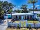 Inviting home with a screen enclosed porch, a well-manicured front yard, and an ornamental fence and gate at 650 S Pine St, New Smyrna Beach, FL 32169