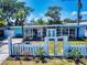 Charming single-story home with a well-manicured front yard, a white picket fence, and a welcoming entrance at 650 S Pine St, New Smyrna Beach, FL 32169