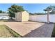 Tan storage shed on brick paver base with white trim and double doors in backyard at 653 Sweetwood Dr, Port Orange, FL 32127