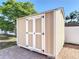 Close up of tan and white storage shed with brick paver base at 653 Sweetwood Dr, Port Orange, FL 32127