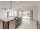 Open kitchen featuring a large island, modern appliances, and sliding glass doors to the backyard at 6808 Forkmead Ln, Port Orange, FL 32128