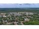 Wide aerial view of a neighborhood featuring many homes, mature trees, and a distant lake at 1119 Wild Oak Ter, Deland, FL 32720