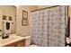 This bathroom features a wood vanity, framed mirrors, and a shower with tub and decorative shower curtain at 1119 Wild Oak Ter, Deland, FL 32720