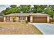 Charming single-story home featuring an attached garage, brick accents and manicured landscaping at 1119 Wild Oak Ter, Deland, FL 32720