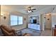 Inviting living room with custom built-in shelving, plush rug, crown moulding, and a ceiling fan at 1119 Wild Oak Ter, Deland, FL 32720