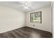 Cozy bedroom with neutral walls, wood-look flooring, a ceiling fan, and a window overlooking the front yard at 126 Brandy Hills Dr, Port Orange, FL 32129