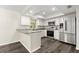 Well-lit kitchen features white cabinetry, stainless steel appliances, and breakfast bar with granite countertops at 126 Brandy Hills Dr, Port Orange, FL 32129